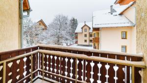 balkon z pokrytymi śniegiem drzewami i budynkami w obiekcie Apartamenty Sun & Snow Osiedle Podgórze w Szklarskiej Porębie