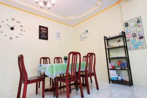 a dining room table with chairs and a clock on the wall at Colourful homestay - (near jeti sky mirror) in Kuala Selangor