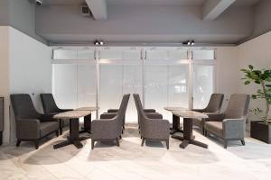 a group of tables and chairs in a room at EN HOTEL Hakata in Fukuoka