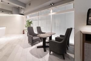 a dining room with chairs and a table and a window at EN HOTEL Hakata in Fukuoka