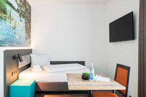 Habitación pequeña con cama y mesa en Hotel Amper en Germering