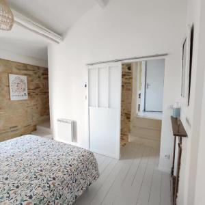 een slaapkamer met een bed en een deur naar een gang bij Le 19 Rue **,Maison de charme proche du Puy du Fou in Mouchamps