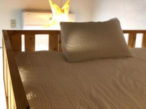 a bed with a pillow sitting on top of it at Hostel Yume-Nomad Kobe in Kobe