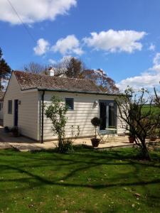 una pequeña casa blanca con un patio de césped en Crosspark, en Kingsbridge