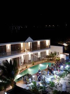 a building with a swimming pool at night at Gia An Hung Guest House in Mui Ne