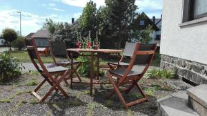 três cadeiras e uma mesa e uma mesa e cadeiras em Ferienwohnung Natur und Steine em Oberbrombach