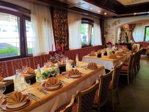 una sala da pranzo con tavoli e sedie lunghi di Hotel Rubino Deluxe a Campitello di Fassa