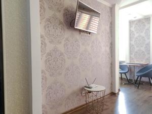 a living room with pink wallpaper and a table and chairs at Apartment Studio in town centr in Kamianets-Podilskyi