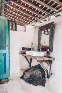 塔巴南的住宿－Batukaru Coffee Estate，一间带水槽和桌子镜子的浴室