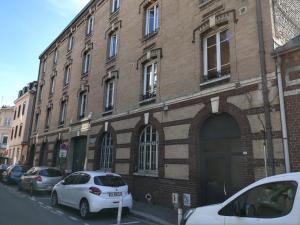 a brick building with cars parked in front of it at Appartements Up & Down by Beds76 in Rouen