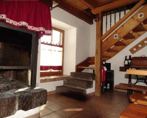 a living room with a fireplace and a staircase at Baita Casera Caviazza in Falcade