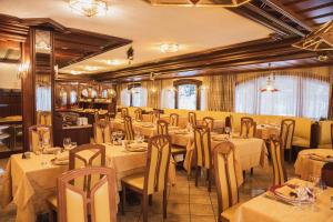 a restaurant with tables and chairs in a room at Hotel Rubino Deluxe in Campitello di Fassa