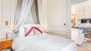 a bedroom with a white bed with a red bow on it at Luxury 3 Bedroom 2 Bathroom Palace Apartment - AC - Louvre in Paris