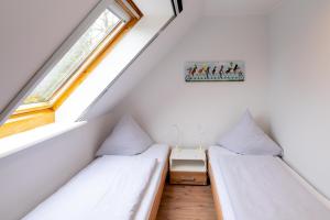 Dos camas en una habitación pequeña con ventana. en Bauernhaus-Wohnung-2, en Bojendorf