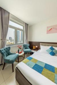 峴港的住宿－Phuc Thanh Luxury Hotel by THG，一间卧室配有一张床、两把椅子和一个窗户