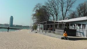 a man standing on a beach next to a building at Domhotel Bed & Breakfast in Schleswig