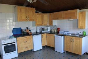 a kitchen with white appliances and wooden cabinets at Pegasus, Les Constellations in Doeuil-sur-le-Mignon