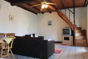 ein Wohnzimmer mit einem Sofa und einem TV in der Unterkunft Pegasus, Les Constellations in Doeuil-sur-le-Mignon