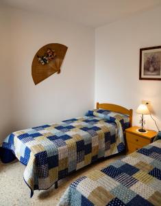 a bedroom with two beds and a table with a lamp at Vivienda Rural Antares in Cómpeta