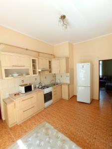 an empty kitchen with a white refrigerator and cabinets at Park House in Rivne