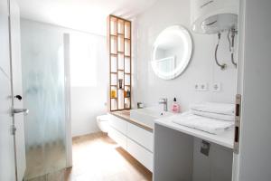 ein weißes Badezimmer mit einem Waschbecken und einem Spiegel in der Unterkunft Apartment Nauta Lux in Malinska