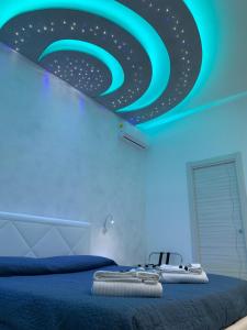 una camera con un letto e un soffitto blu di B&B Vittorio Emanuele a Licata