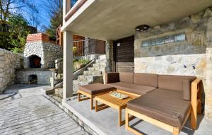a patio with a couch and a table and a fireplace at By Riverhill in Karlovac
