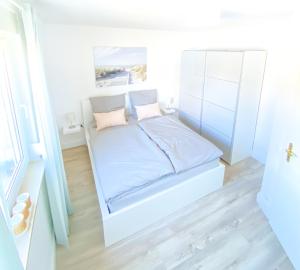een klein wit bed in een kleine kamer bij Frieda´s Ostseetraum in Börgerende-Rethwisch