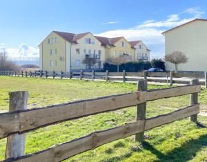 een houten hek voor een veld met huizen bij Frieda´s Ostseetraum in Börgerende-Rethwisch