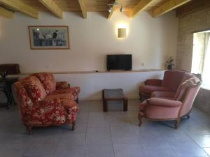 sala de estar con 2 sillas y TV de pantalla plana en Gemini, Les Constellations Gite Complex, en Doeuil-sur-le-Mignon