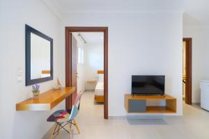 ein Wohnzimmer mit einem TV und einem Spiegel in der Unterkunft Villa Lithi in Limenaria