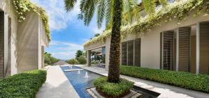 an exterior view of a villa with a swimming pool and palm trees at Sangsuri Villa 3 in Choeng Mon Beach
