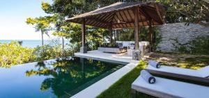 an infinity pool with a pavilion next to the ocean at Sangsuri Villa 3 in Choeng Mon Beach