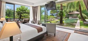 a bedroom with a bed and a large window at Sangsuri Villa 3 in Choeng Mon Beach