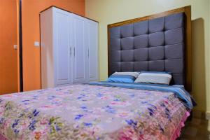 a bedroom with a large bed with a large headboard at Hôtel Saint Jean Leopold in Kigali