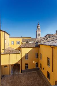 vistas a un edificio amarillo con una torre de reloj en Palazzo Le Poste - Suite and Apartments, en Parma