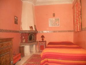 a bedroom with a bed and a fireplace at We look forward to welcoming you to our home in Essaouira