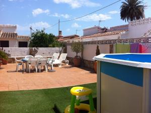 un patio trasero con mesa, sillas y piscina en Villa with garden and pool in Denia, en Denia