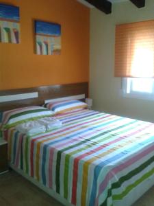 1 dormitorio con 1 cama con manta a rayas en Villa with garden and pool in Denia, en Denia