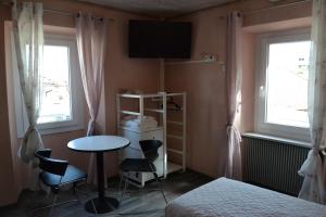una camera con tavolo, letto e TV di Casa Buby a Cadenazzo