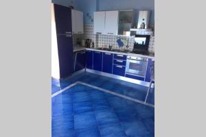uma cozinha com armários azuis e um piso azul em Casa Alexandr Piedigrotta em Pizzo