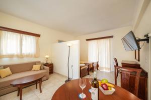 ein Wohnzimmer mit einem Sofa und einem Tisch in der Unterkunft Aqualand Resort in Ágios Ioánnis