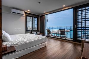 a bedroom with a bed and a view of the ocean at Marbordo B&B in Xiaoliuqiu
