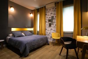 a bedroom with a bed and a desk and a chair at Boutique Hôtel Azur in Marseille +97 photos