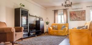 a living room with two chairs and a television at Fonte da Rosa Guest House APT2 in Belmonte