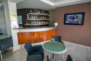 a bar with a table and chairs and a tv at Crystallo Apartments in Paphos
