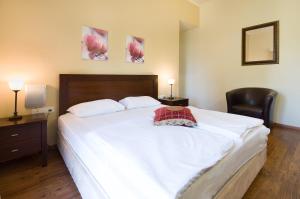 a bedroom with a large white bed and a chair at Zohar Badeshe in Daliyya