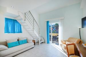 a living room with a couch and a staircase at Aqualand Resort in Agios Ioannis