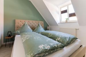 ein Schlafzimmer mit einem Bett mit grünen Kissen in der Unterkunft Ferienwohnung hinter der Krämerbrücke in Erfurt