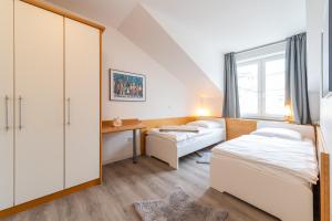 a bedroom with two beds and a desk and a window at Appartment Strandduene in Binz